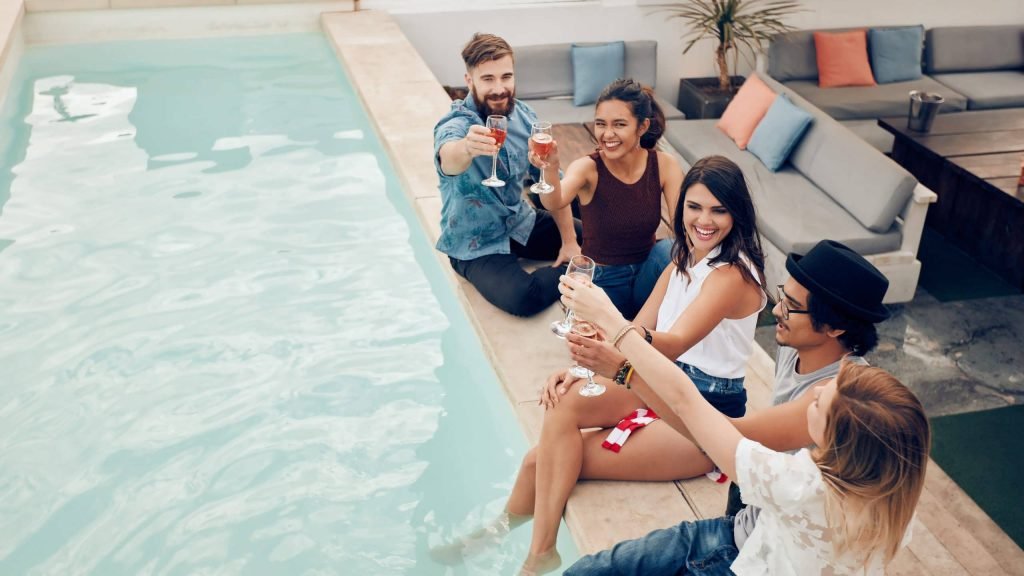 group-of-friends-toasting-at-pool-party-outdoor-PG69YCW-scaled