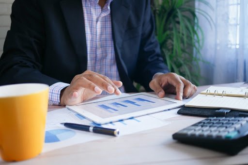 A businessman reviewing a bar chart in different shades and tints of blue.